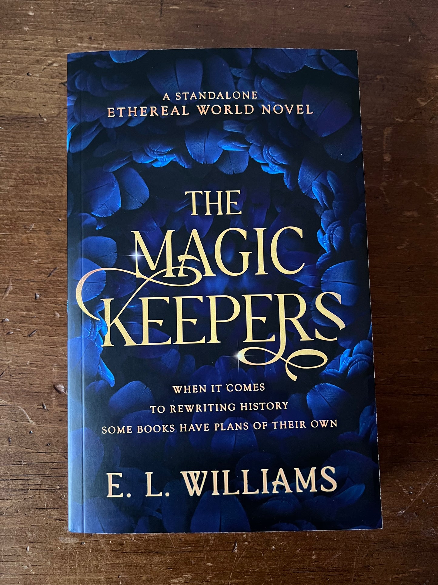 Book titled 'The Magic Keepers' by E.L. Williams on a wooden surface
