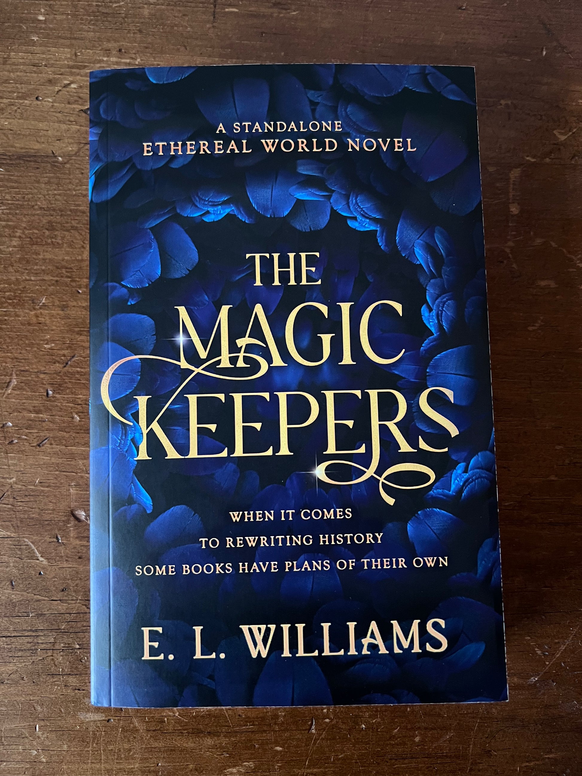 Book titled 'The Magic Keepers' by E.L. Williams on a wooden surface